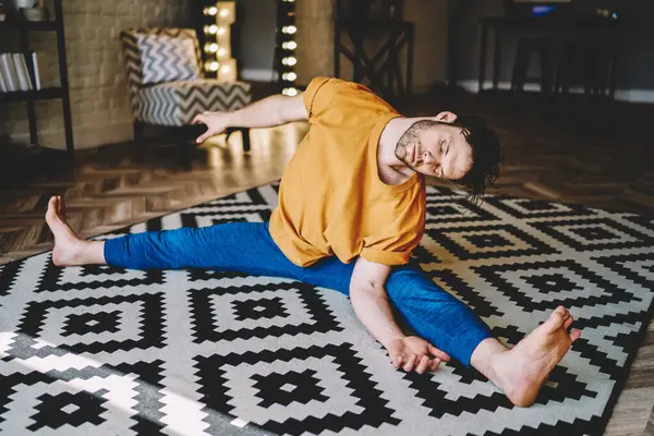 Konzentrierter Lässiger Barfuß Mann Sitzt Mit Gespreizten Beinen Auf Teppich — Stockfoto