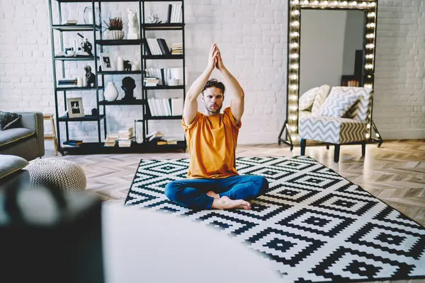 Junger Stylischer Mann Sitzt Auf Yogamatte Mitten Modernen Wohnzimmer Bequemer — Stockfoto