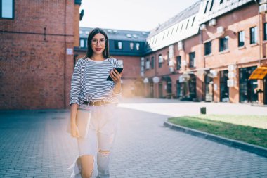 Kaygısız kadın milenyumu dijital akıllı telefon aygıtı ve netbook 'a odaklanın ve öğrenim için kameraya bakın, cep telefonlu güzel İspanyol blogcunun yarım boy portresi