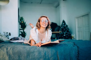 Klasik gözlüklü neşeli kadın portresi. Edebiyat hobisi için eğlenmek, hafta sonunu evde geçirmek, dinlenmek, zevk almak ve dinlenmek için.