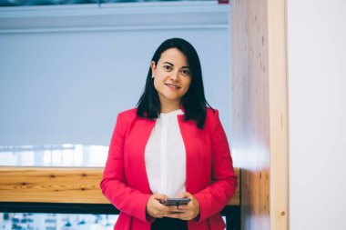 Resmi olarak giydiğim yarım boy portre ya da güzel esmer kadın ofiste gezmek ve bankacılık için cep telefonu kullanıyor, 30 'ların iş kadını kameraya bakıyor ve internette cep telefonu sohbeti yapıyor.