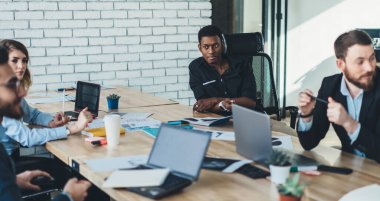 Siyahi, düşünceli, zeki, sakin girişimci, şirket stratejisi ile ilgili görüşmeler sırasında meslektaşlarına bakıyor.