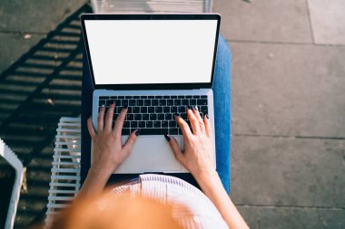 Modern dizüstü bilgisayarda yazı yazan kadının üst görünümü ekran görüntüsü açık havada çalışıyor; klavyede kesilen kadın eli görüntüsü ve blog yazma teknolojisi.