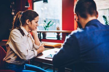 Gündelik kıyafetlerle meşgul bir kadının dizüstü bilgisayar kullanarak Cafe 'de el ele oturarak proje yaratması.