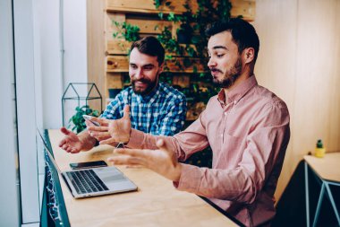 Şık tişörtlü erkek arkadaşlar el ele tutuşup gülüyorlar. İş planlarında hata yapıyorlar. Hem de rahat bir kafede. 