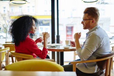 Zarif, canlı kırmızı gömlekli muhteşem yetişkin bir kadının arka planı. Masadaki rahat koltukta oturmuş, düşünceli bir adamın, bulanık camlı kahve dükkanının bulanık duvarlarına karşı hikâyeler anlatırken ilgiyle ve düşüncelere dalmış bir şekilde başka tarafa bakıyor.