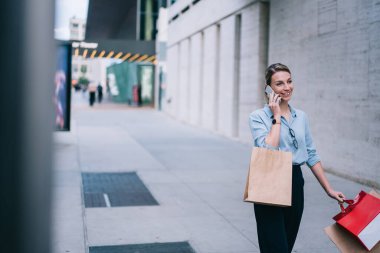 Güzel alışverişin ardından alışveriş merkezinde kağıt poşetlerle gezerken şık genç bir kadın arıyor, hippi kız mağazalardan günlük kıyafetler alıyor ve cep telefonuyla Kara Cuma hakkında konuşuyor.
