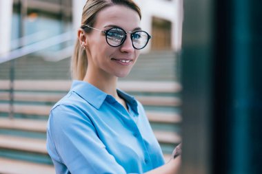 Yenilikçi ekranda ileri dijital teknolojiyle gülümseyen kadın. Genç bir kadın dışarıda dikilirken bilgi bulmak için interaktif kiosk ekranına dokunuyor.