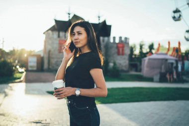 Ciddi bir Asyalı kız öğrenci yaz akşamı boş zamanlarında şehir sokaklarında yürürken cep telefonuyla arama yapıyor. Düşünceli hippi kız gezgin bir bağlantı kurmak için bekliyor.