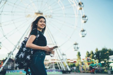 Neşeli Asyalı genç kadın turistin portresi cep telefonuyla festival merkezine giderken, eğlence ve tekerle, gülümseyen hippi kız yaz tatillerinin tadını çıkarıyor.