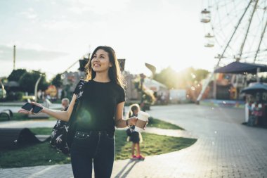 Neşeli Asyalı kadın rahat giyiniyor. Mutluluk hissediyor. Hafta sonlarını eğlence ve eğlence için parkta geçiriyor.