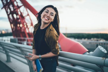 Modayı takip eden eğlenceli Asyalı öğrencinin portresi hafta sonları cep telefonuyla eğleniyor, gözlüklü kaygısız blogcu şehirde boş zamanlarında kameraya bakıyor.