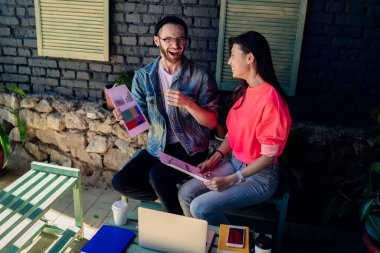 Mesut erkek ve kadın meslektaşlar proje oluşturma ve bilgi analizi için iş birliği yapıyorlar. İyi arkadaşlığın tadını çıkarıyorlar. Heyecanlı hippi öğrenciler öğrenim sırasında gülüyorlar.