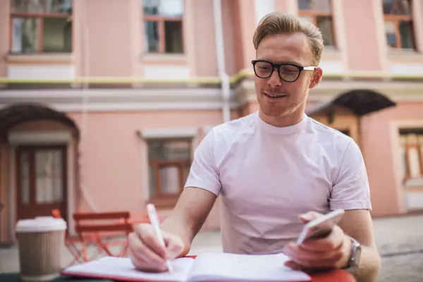 Homem Positivo Desgaste Casual Óculos Escrevendo Memorando Caderno Tomando Café — Fotografia de Stock