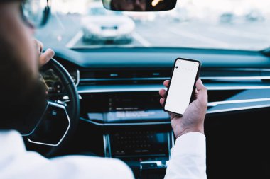 İdari şoförün akıllı telefon uygulaması üzerinden GPS konumunu takip etmek için cep telefonu teknolojisini kullanmasının arka planı, iş adamının otomotiv tekeri ve telefon kullanması