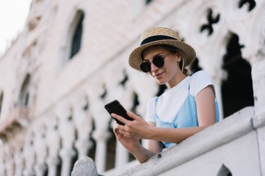 Beyaz kadın turist yaz tatillerinde tek başına Venezuela 'ya yaptığı seyahatle ilgili içerik yayını yapıyor, milenyum kadını İtalya' da gezinen interneti kullanarak kamu sitesinde seyahat haberleri okuyor.