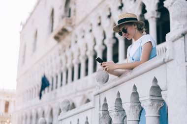 İtalya 'da yaz tatillerinde hasır şapka ağı haberleri okuyan mutlu bir turist, gezmek için gezici internet sitesine bağlanan gülümseyen bir kadın milenyum.