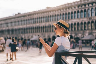 Mutlu Kafkasyalı kadın akıllı telefondan bilgi topluyor. İnternet üzerinden seyahat rehberi okuyor. Venedik 'i keşfediyor, İnternet' e bağlanan gülümseyen kadın turist konum uygulaması için geziniyor.
