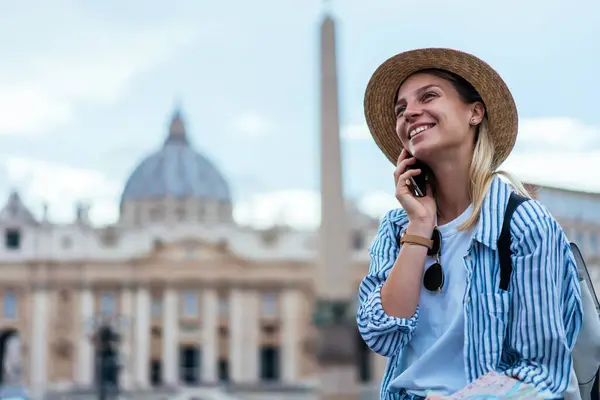 Joyful Caucasian tourist making roaming smartphone call communication for discussing Italian solo journey, happy woman 20 years old enjoying positive conversation while phoning via cell app