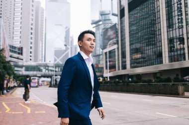 Güvenilir ve saygın Asyalı iş adamı. Katı mavi takım elbiseli ve temiz pembe gömlekli. Şehir merkezinde otobüs durağı yakınında.