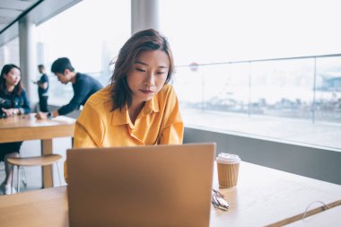 Asyalı kız öğrencilerin Hong Kong 'da panoramik pencereli bir kafede kahve içerken masaya bakıp düşündüklerinden şüphe duymak.