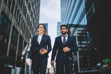 Katı siyah takım elbiseli çok ırklı iş arkadaşlarının yaz aylarında sokaklarda birbirleriyle konuşmalarından.