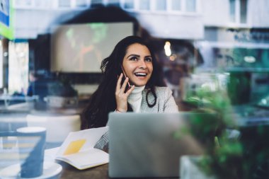 Neşeli milenyum kadını kameraya gülümserken üniversite arkadaşını bilgi ödevi hakkında konuşmak için arıyor. Uzaktan kumandalı telefonla uzaktaki meslektaşıyla iletişim kuruyor.