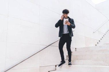 Modern stil gülümseme, gündüzleri şehir merdivenlerinde dikilirken günlük kıyafetleriyle konuşan ve tablet kullanan Afro-Amerikalı genç esmer adam için heyecan vericiydi.