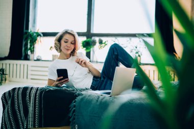 Güzel bir kadın, rahat bir dairede, rahat bir yatakta uzanıyor. Dairenin içinde ve okuyor. Mesajla ilgilenen akıllı telefon mesajı alıyor.