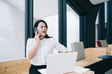 Cep telefonu görüşmeleri sırasında çığlık atan, kızgın, kızgın, kızgın 30 'lu iş kadını şikayet etmek için akıllı telefon görüşmesi yapıyor.