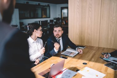 Modern konferans odasında çeşitli aletlerle masada otururken resmi kıyafet yöneticisi anonim CEO 'ya soru soruyor.