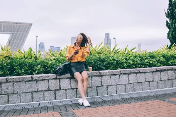 Isi Tertawa Wanita Asia Dengan Rambut Terbang Memegang Smartphone Sambil — Stok Foto