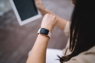 Uygulama reklamcılığı için dokunmatik ekranı olan akıllı modelleme uyarısı alan bin yıllık kadın kontrolünün kırpılmış resmi, boş ekran ile giyilebilir aygıt üzerine seçici odaklanma