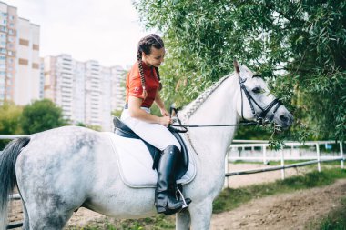 Düşüncesiz bayan jokeyin safkan at biniciliğinin keyfini çıkarması, beyaz profesyonel kadının ata binmesi, kısrak üzerinde oturması, binicilik sporu yapması.