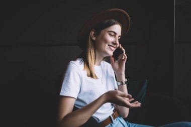 Moda kıyafetleri içinde gülümseyen beyaz kadın ve cep telefonuyla konuşan, güler yüzlü 20 'li yaşlardaki hippi kız, akıllı telefon görüşmesi yapıyor ve boş zamanın tadını çıkarıyor.