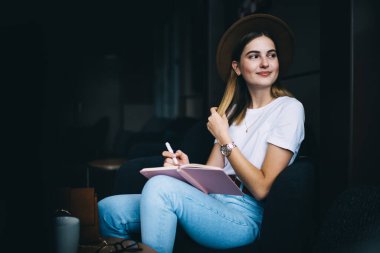 Beyaz kadın 20 'li yaşlarda şık giyinmiş bir blogcu. Makaleler ve yayınlar yaratmaktan zevk alıyor. Not defterinde yazan güzel kadın hipster boş zamanlarında kafede oturuyor.