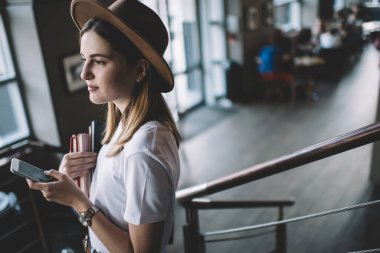 Ciddi beyaz kadın 20 'li yaşlarda şık giyiniyor. Cep telefonu numarasını kapalı bir yerde tutuyor. Düşünceli çekici kız öğrenci milenyumu.