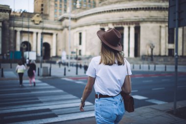 Kadın gezginlerin modaya uygun kıyafetleri ve şapkalarıyla şehir merkezindeki caddelerde yürürken, Kafkasyalı 20 'li yaşlarda kadın gezgin şehir kavşağındaki varış noktalarına ve mekanlara doğru yürüyor.