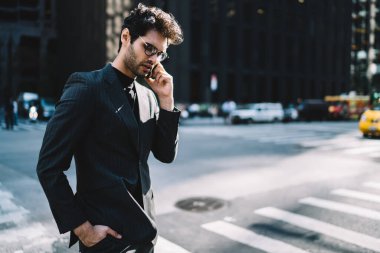 Şık giyinmiş Avrupalı bir adam cep telefonu uygulaması üzerinden uluslararası akıllı telefon görüşmesi yapmak için gezici internet bağlantısını kullanıyor.