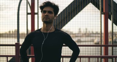 Genç vücut geliştirici şehir merkezindeki kardiyo karın kasları eğitimine hazır. Elektronik teknolojide Avrupalı erkek sporcu. Sokak eğitimine hazırlanan motivasyon çalma listesi.