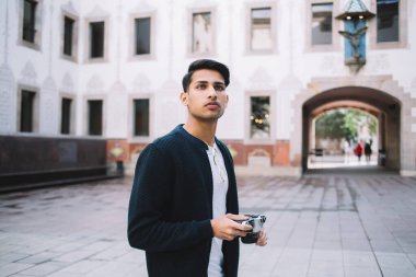 Ciddi düşünceli Hintli 20 'li yaşlarda şık giyinen bir erkek şehir merkezini ve önemli yerleri keşfediyor. Düşünceli hippi adam tatillerde kentsel ayarı çektiği için kamera tutuyor.