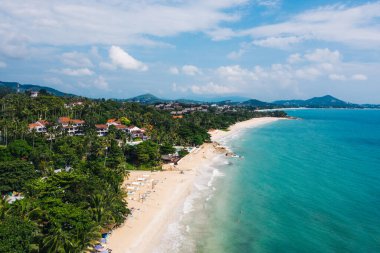 Turkuaz berrak deniz suyuyla beyaz kumsal manzarası. Kumsalda otelleri olan resimli gölün kuş bakışı panoramik manzarası. Tayland 'da nüfuslu bir ada