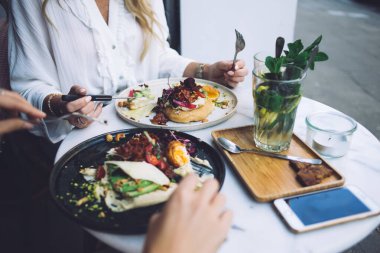 Bayan arkadaşların kafeteryada birlikte yemek yerken çekilmiş görüntüsü sağlıklı sebzelerin tadını çıkaran kadınlar, sağlıklı beslenme menüsü ve yaşam tarzı için modern mutfakların lezzetli yemeklerinden tatmin olan kadınlar.