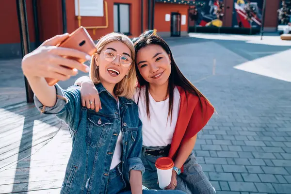 Selfie içeriği ve sosyal paylaşım için 4G 'ye bağlanan mutlu kadın kullanıcıların portresi, 20 yaşındaki çeşitli hipster kızlar video çekerken kameraya gülümsüyor