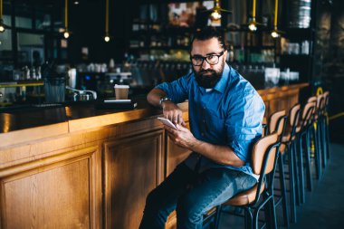 Küçük iş yeri sahibi, yakışıklı, olgun bir adamın portresi. Cep telefonu taşıyor. Mesajlar gönderiyor.