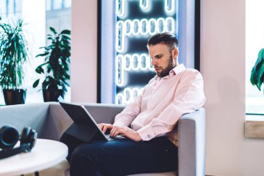 Kafkasyalı bir adam, pazarlama için modern dijital tablette 4G kablosuz ile bağlantılı bitcoin takası hakkında bilgi edinmek için birlikte çalışıyor ve araştırıyor.