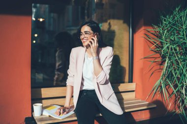 Göz düzeltmesi için optik gözlük takan neşeli kadın milenyumu. Kaldırım kafeteryasında planlama yaparken arkadaşınla uluslararası iletişimin keyfini çıkarıyor. Gezmek için gezen zengin kadın.
