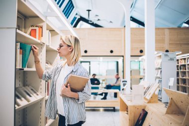 Kütüphanedeki raftan kitap alan beyaz bir kadın üniversitede kendini yetiştirme edebiyatı arıyor. 20 yaşında zeki bir kadın kütüphaneci en çok satan kitapçıyı iş sırasında kitaplığa koyuyor.