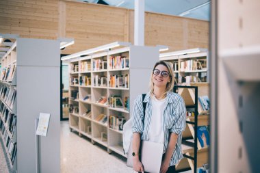 Klasik gözlüklü güzel beyaz gazetecinin yarım boy portresi ve modern dizüstü bilgisayarda uzaktan kumandalı iş için uygun yeri netbook pozu veren çekici bir kadın.