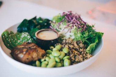 Sotelenmiş ıspanak, avokado ve taze salatayla kremalı sosu karıştırılmış sağlıklı yeşil fasulyeyle servis edilen sulu sığır pirzolası ve yaban pilavı.